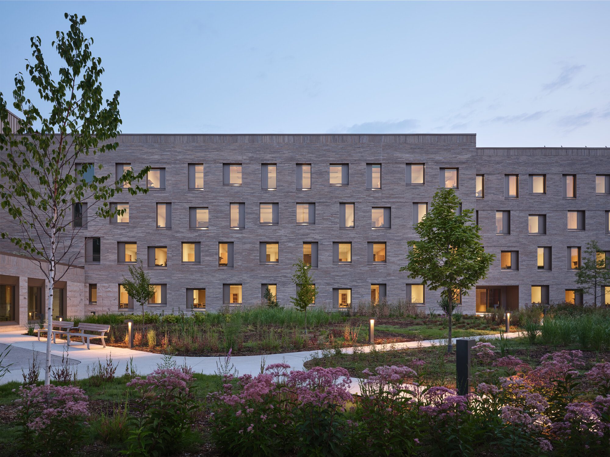 Student residence corridor with timber finishes leading to single and double dorm rooms