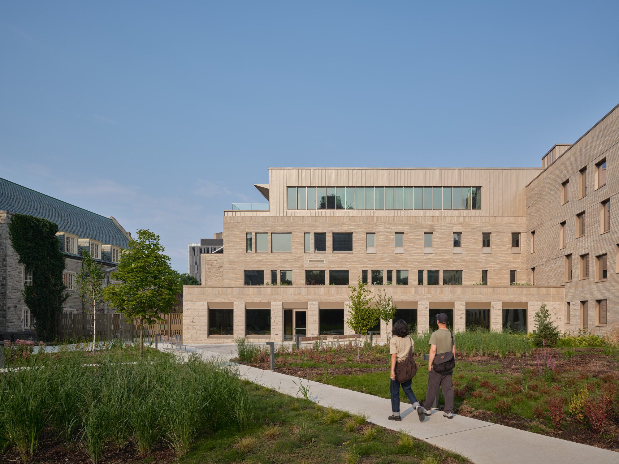 Rooftop urban farm plots arranged beside photovoltaic panels above the college campus