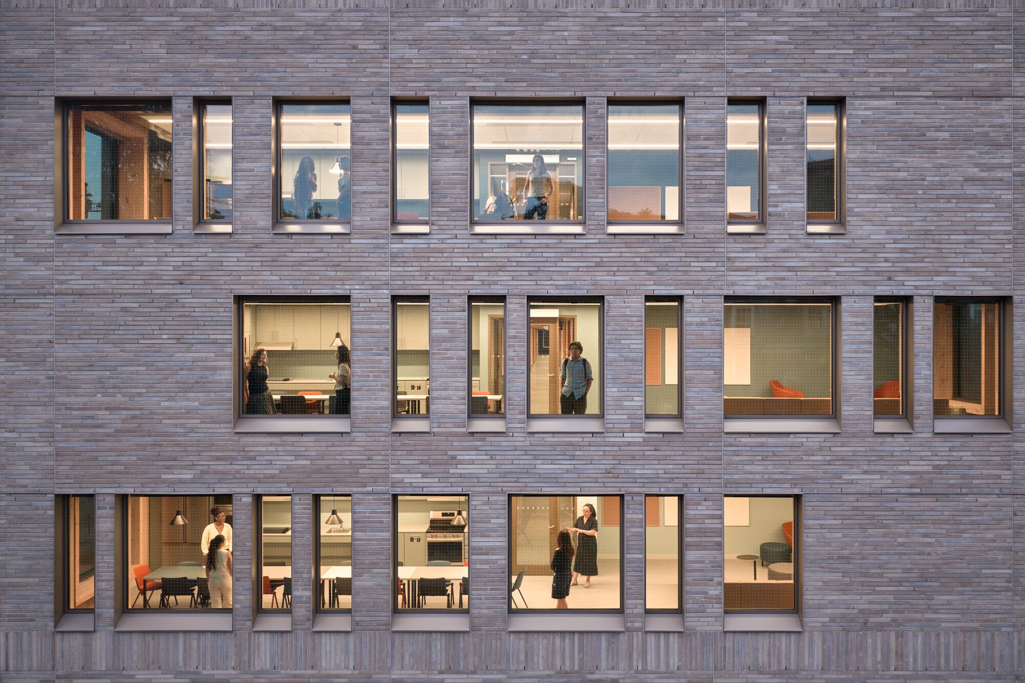 Interior with exposed timber structure, natural daylight, and views toward planted courtyards