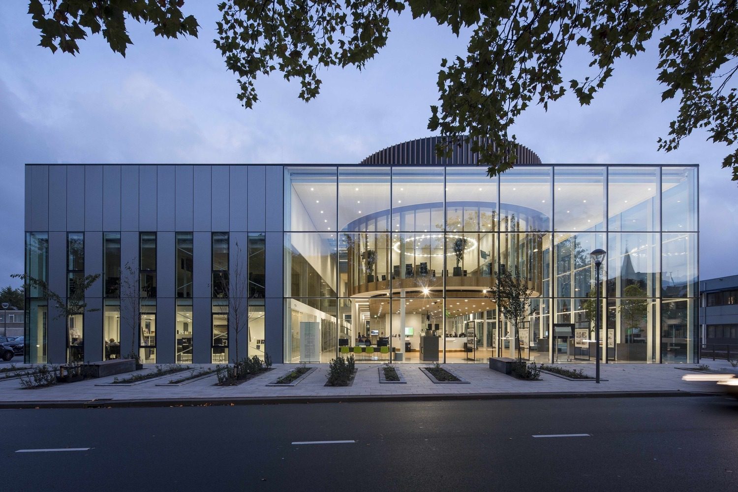 Glass facade of Westland Town Hall reflecting light by architectenbureau cepezed