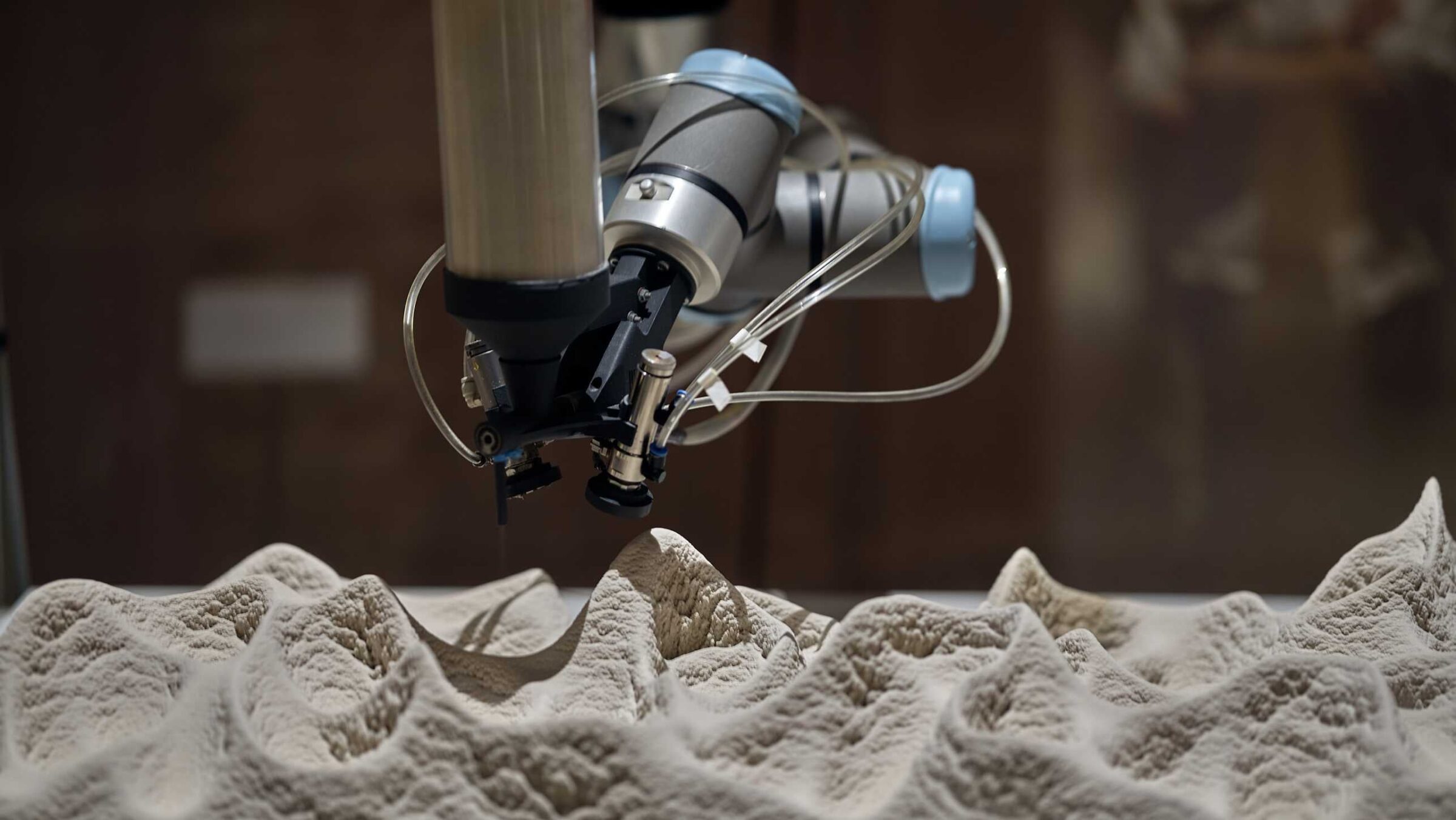 Robotic arm layering sand, bacteria and mineralization substances at the Venice Architecture Biennale