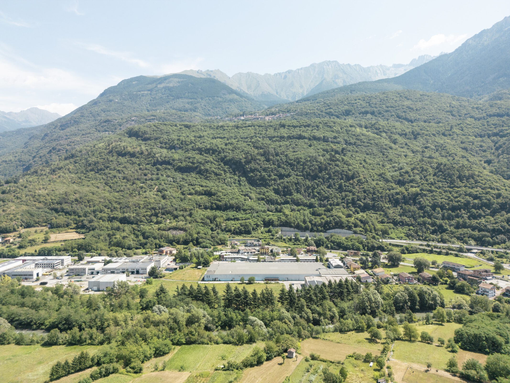 Industrial mill buildings in Ceto set within the landscape at the entrance to Valle Camonica