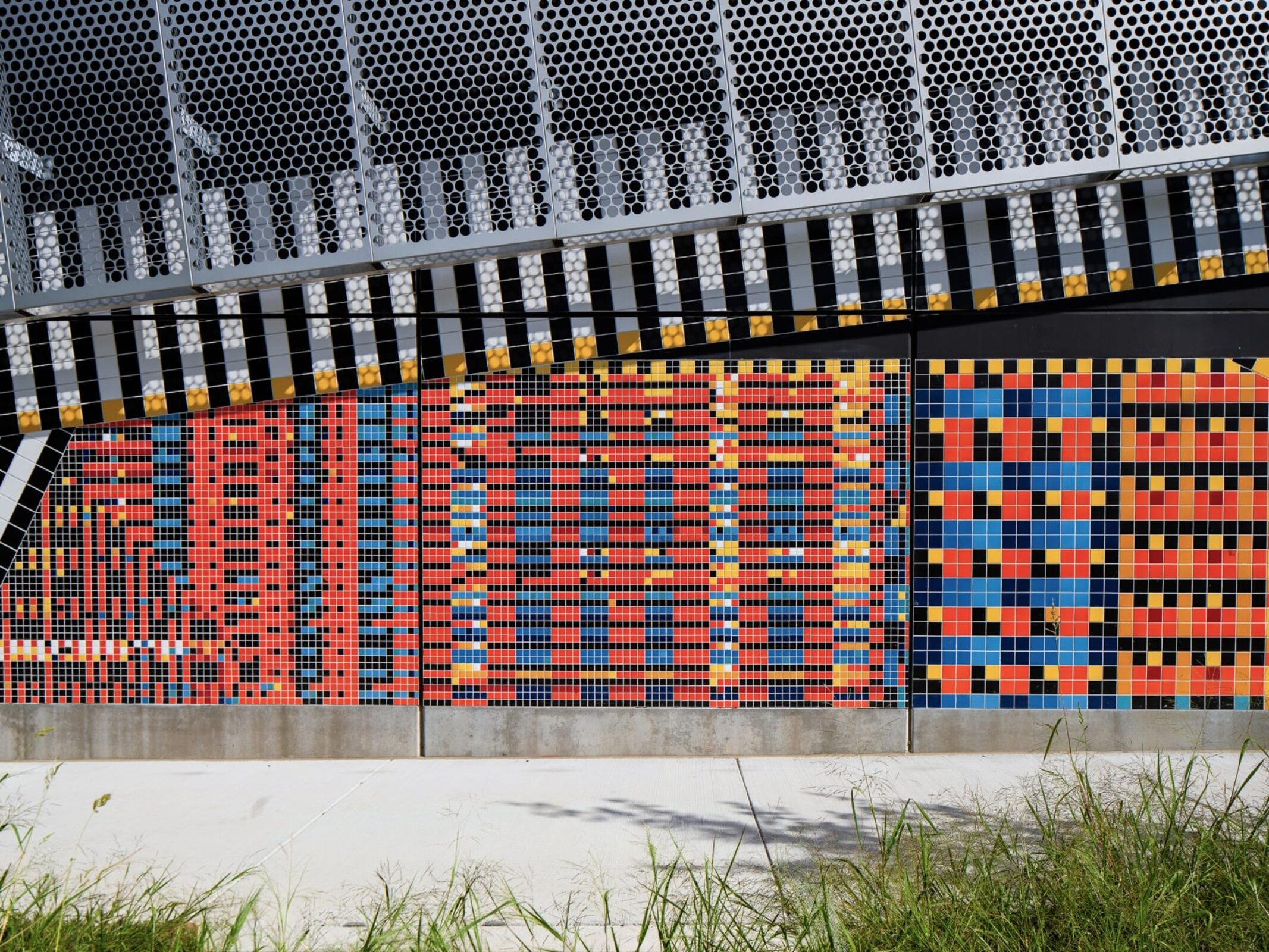 Two-band facade of the substation with textured lower section and monochrome upper surface