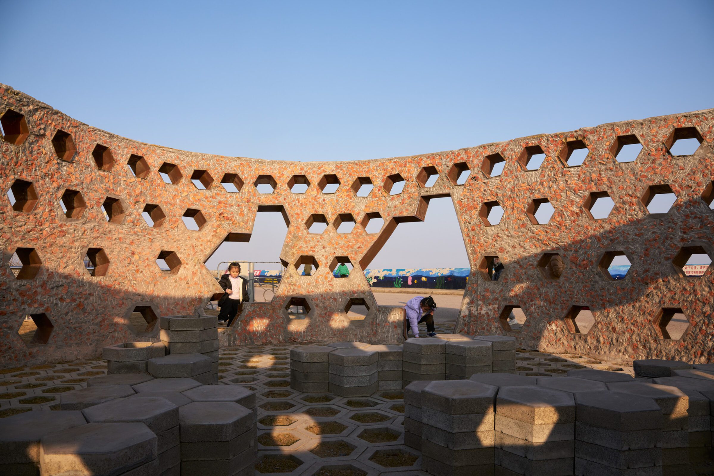 Rough chiseled surface of the recycled brick wall by HCCH Studio with Corten steel openings
