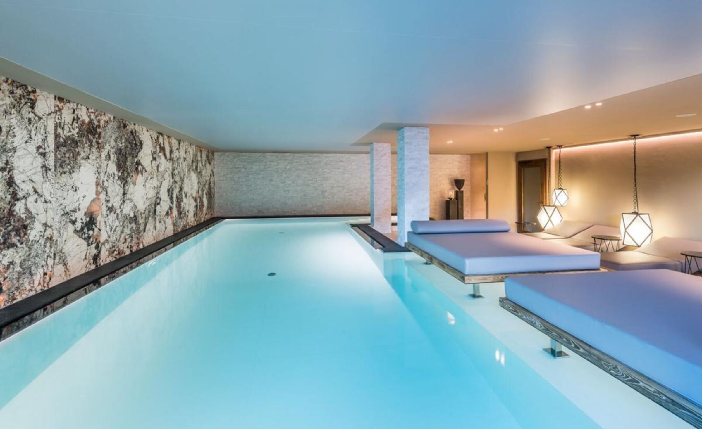 Indoor swimming pool at Revivo Spa opening to the outdoors through sliding glass doors